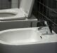 A white toilet sitting next to a white sink