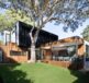 brown wooden house near green trees during daytime